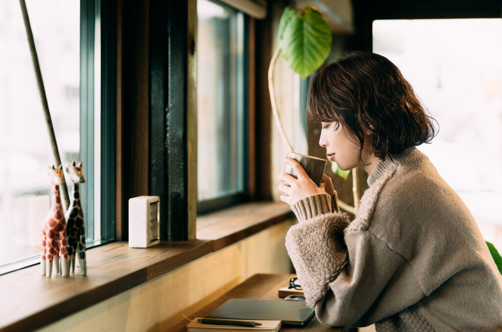 カフェのドリンクで温まる女性